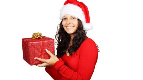 girl in santa hat with present